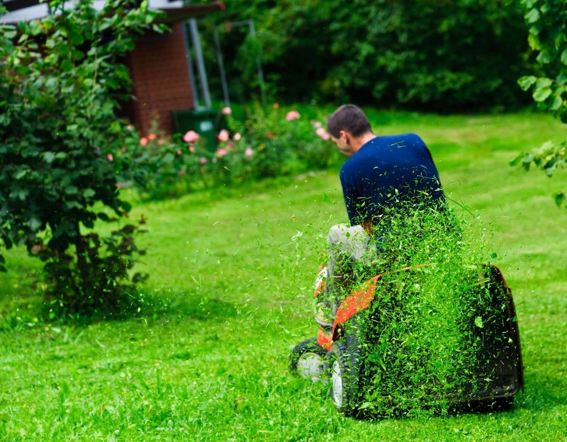 A man is using an electric grass trimmer.